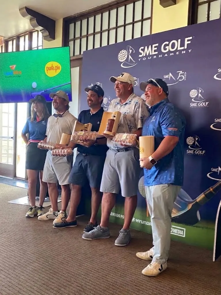 El equipo ganador del SME Golf Tournament recibe los cartones de huevos de punto.pio
