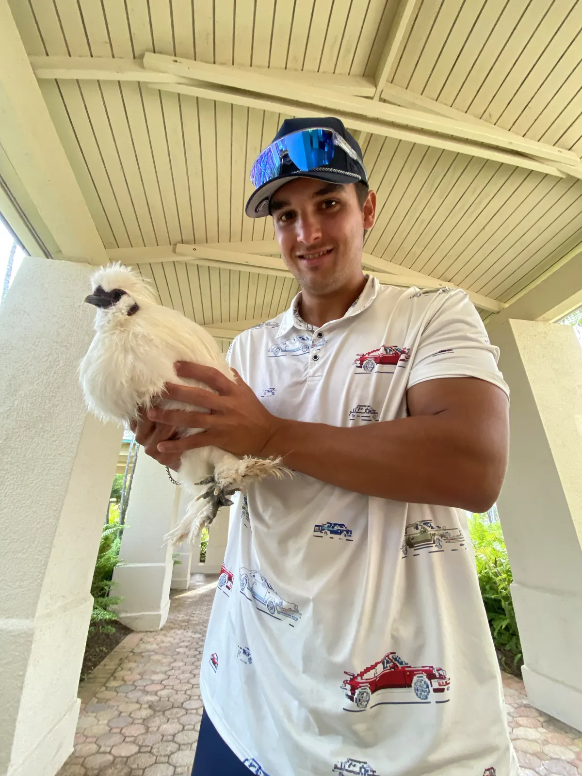 Un golfista sostiene una gallina Silkie durante el torneo